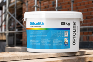 Opakowanie tynku silikonowego Silcolith Optolith 1,5 mm 25 kg na tle placu budowy, realistyczna miniatura produktu.